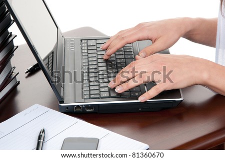 Hands typing on the laptop computer keyboard in an office at a workplace isolated on a white background
