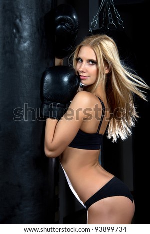Sports Boxing Woman in black box gloves hit punching ball in fitness gym