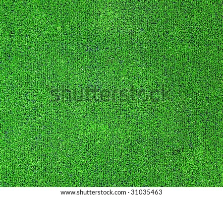 A green artificial grass for sports fields, covering, gardens. Plastic or grass background texture