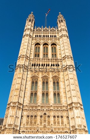 Tower in the building of British Parliament with red bus