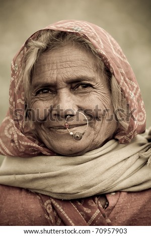 UDAIPUR, INDIA - CIRCA JANUARY 2007: An old Indian woman with traditional nose-ring smiles in the fields circa January 2007 in Udaipur, India.