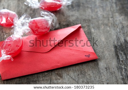 Red envelope and candy  on wooden background