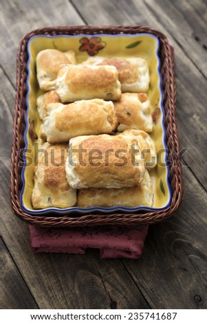 Box with homemade puff pastry closeup on a wooden table.