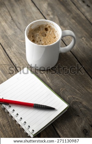 coffee and notebook on working desk, close up