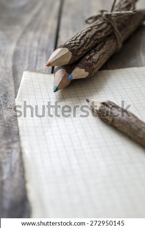 Group of bark covered branch multicolored pencils on wooden  background