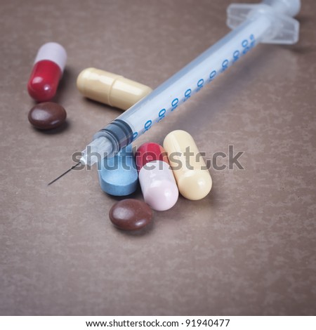 insulin syringe and drugs on wooden table