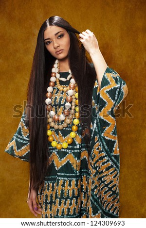 Woman in ethnic dress with long hair in the studio
