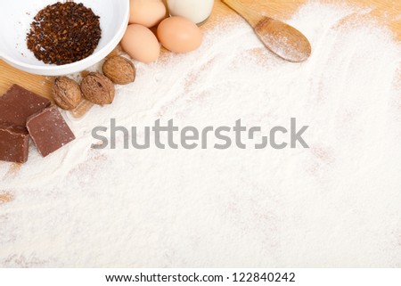 Food ingredients in flour on wooden table - copy space.