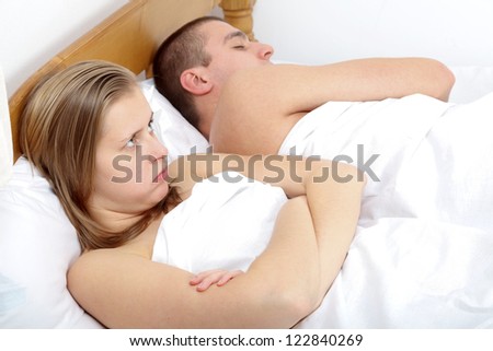 Couple lying in bed having sexual issues.