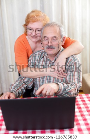 Elderly couple hugging each other at home.
