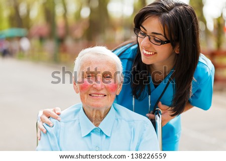 Caring nurse or doctor looking kindly on the elderly patient.