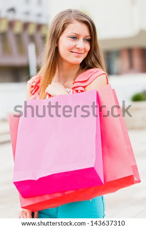 Cute girl holding many shopping bags and smiling lovely.