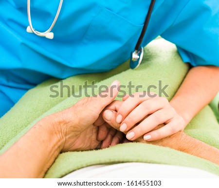 Health care nurse caring for elderly concept - holding hands.