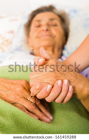 Care help love and trust to elderly people - holding hands.
