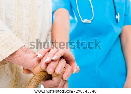 Caring doctor supporting elderly patient in her struggle - residential care.