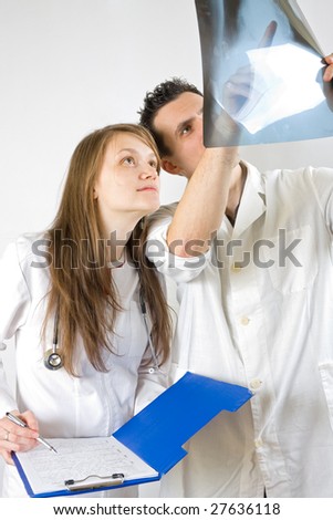 Two doctors - male and female - analysing an x-ray image of a sick patient.