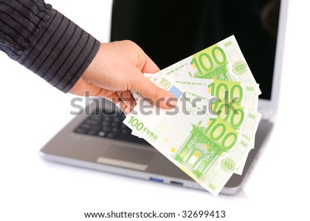 A male man holding in his hand 400 Euro, a laptop in the background.