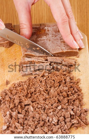 A female cook \'s hands frittering baking chocolate for cookies or cupcakes.