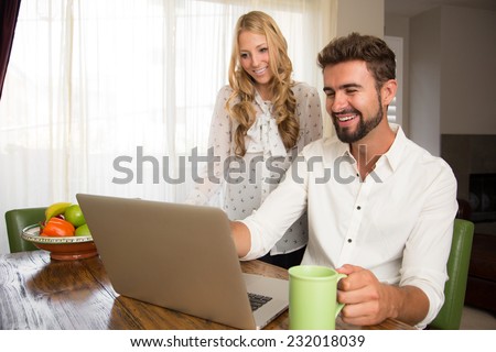 Couple watching a video on the pc in the kitchen