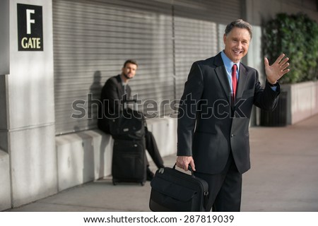 Successful executive man calls taxi cab after arriving from trip