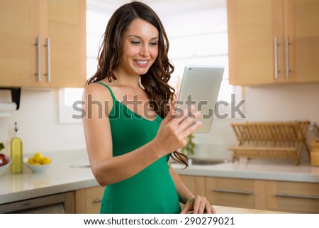 Beautiful woman with perfect smile teeth skin hair on her tablet computer browsing the web and chatting