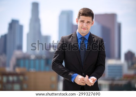 Charming handsome business man adjusting suit cuffs and smiling cunning confidence in city