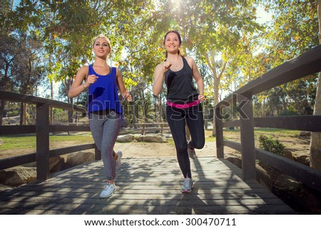 Females jogging to stay fit exercise cardio outdoor natural park nature setting on beautiful day