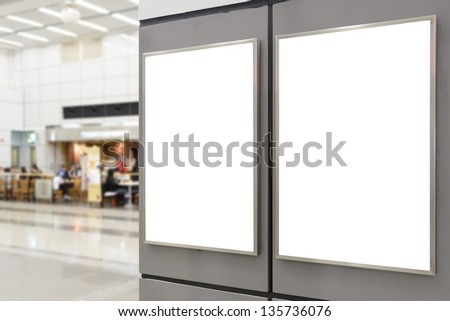 Two big vertical / portrait orientation blank billboard on wall in public open space with blurred cafe background