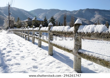 Snow-covered old rural wooden fence