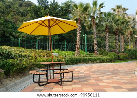 Patio umbrella with blue sky and tree background