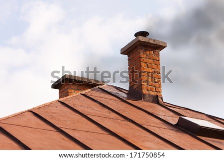 Chimney with neglected maintenance emitting air pollution due to improper burn of solid fuels in wood stove during heating season.