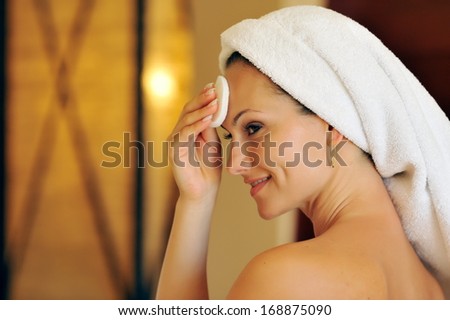 profile view of happy young woman cleansing her face