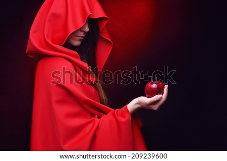 beautiful woman with red cloak holding red apple