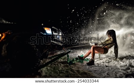 young athletic woman pulling car in winter