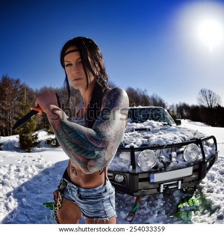 young athletic woman pulling car in winter