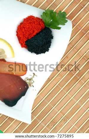 red and black fish caviar and dried fish on a white plate
