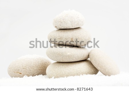 pile of river stones in the snow on grey background