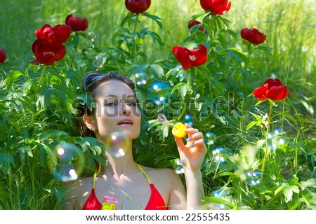 young woman outdoor blowing soap balloons