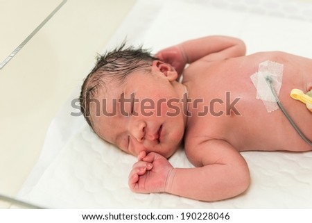 New born male baby from first day in operating room, taken indoor
