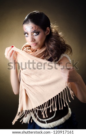 The model covers her face with a scharf. Professional makeup painting is applied on her face