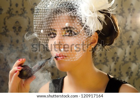 Sophisticated woman smoking pipe in a retro location