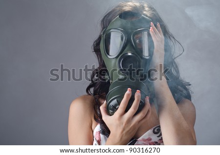Female wearing a gas mask for protection against the cigarette smoke