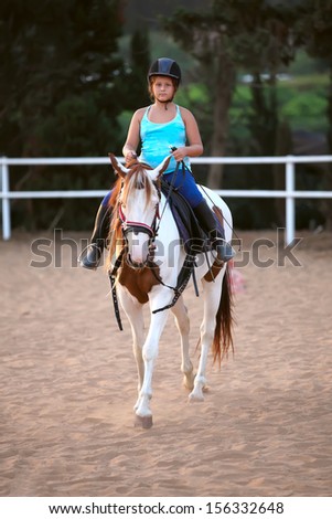 A little girl getting a horseback riding lesson