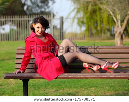 young women in red coat posing in park