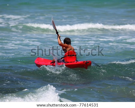 boy rowing in sea kayak