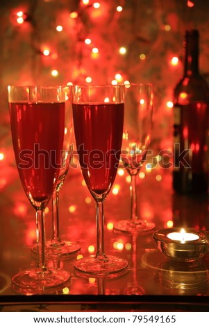 Champagne in glasses, candle light an twinkle lights on background.