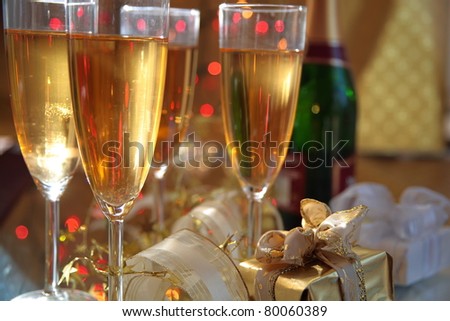 Champagne , glasses.bottle and gift box on gold background.