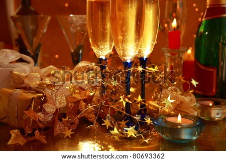 Champagne in glasses ,candle lights,gift boxes and light on background.