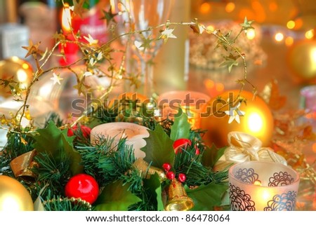 Closeup of christmas decoration with baubles,candle lights,gift and twinkle lights on golden background.