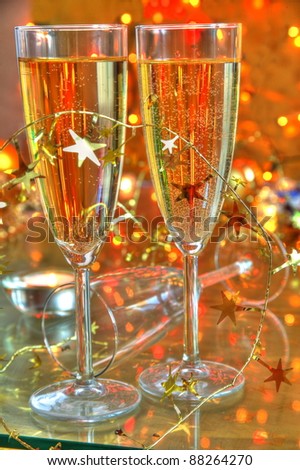 Closeup of champagne in glasses,candle light and twinkle lights on background.